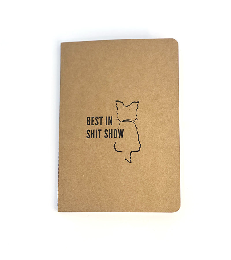 Brown notebook with 'Best in Shit Show' text and a dog illustration on a white background