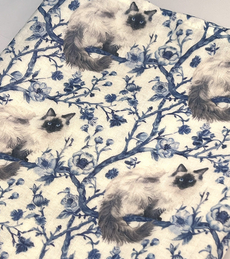 Fabric with Birman cat pattern on a blue floral and branch design