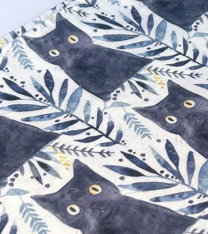 Patterned fabric with black cats and blue leaves 