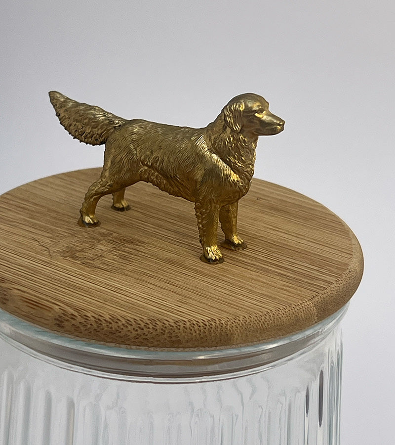 Glass jar with a wooden lid featuring a Golden Retriever dog figurine on a plain background