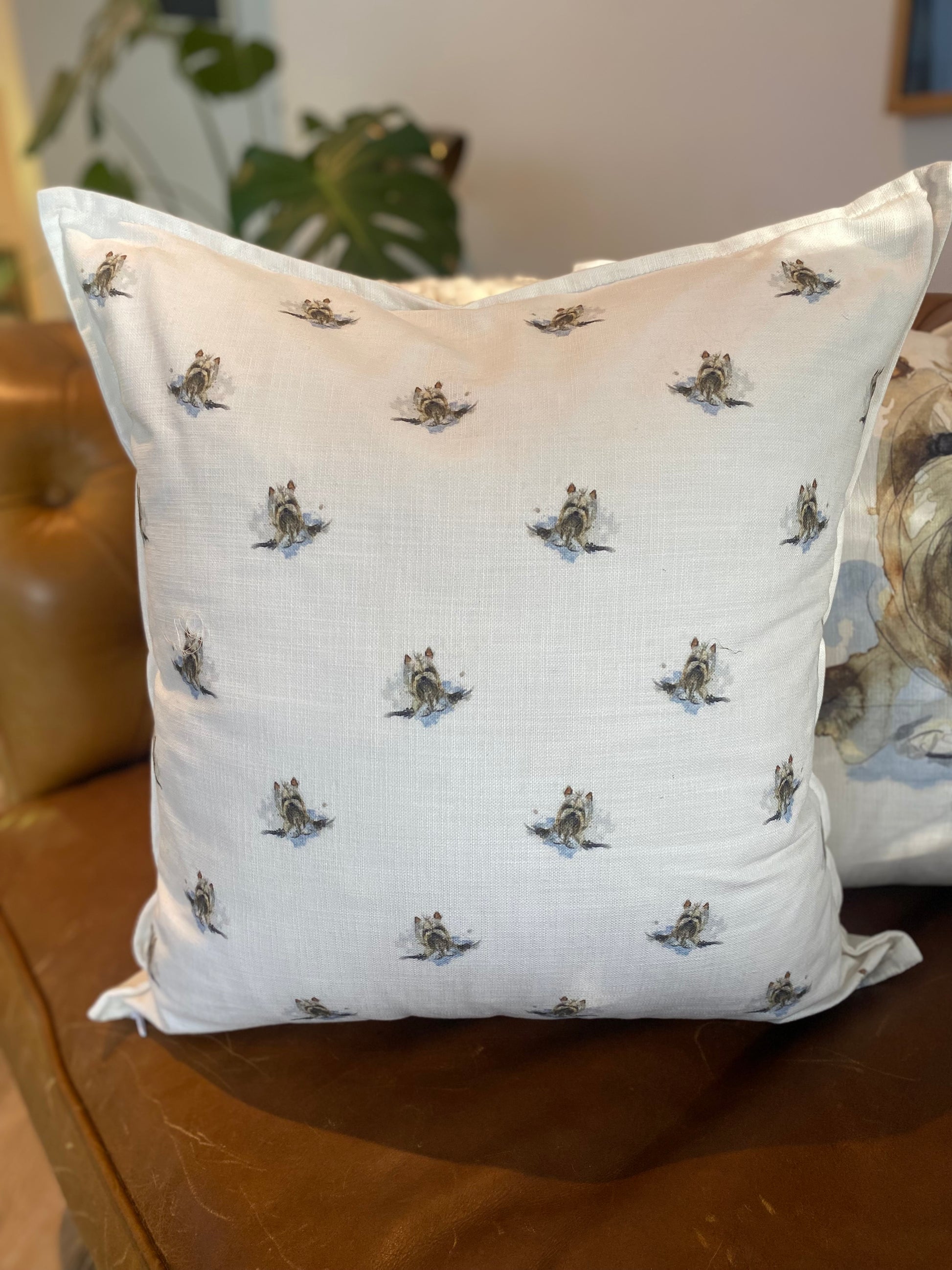 White pillow with small dog pattern on a brown surface