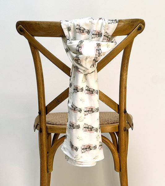 Scarf with dog pattern draped over a wooden chair against a white background