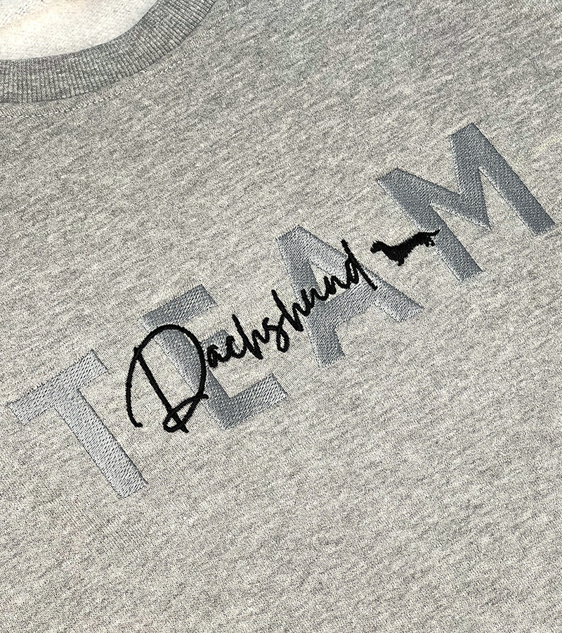 Gray sweatshirt with 'TEAM Dachshund' text and dog silhouette image on a plain background