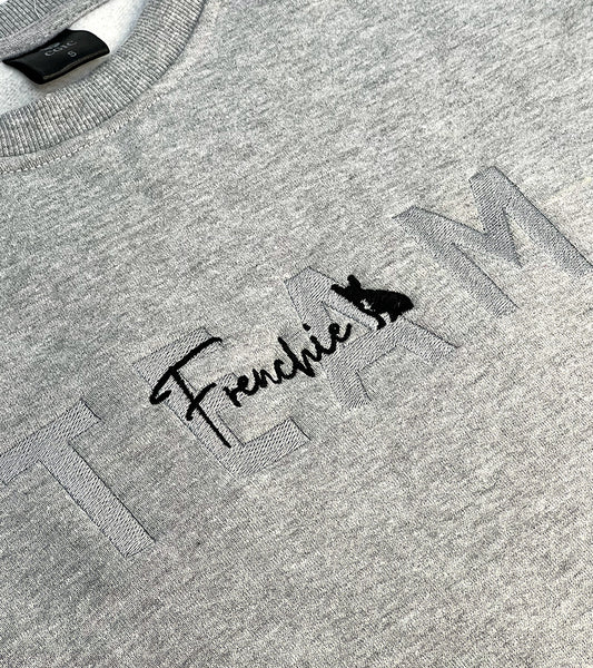 Gray sweatshirt with 'TEAM Frenchie' text and dog silhouette image on a plain background