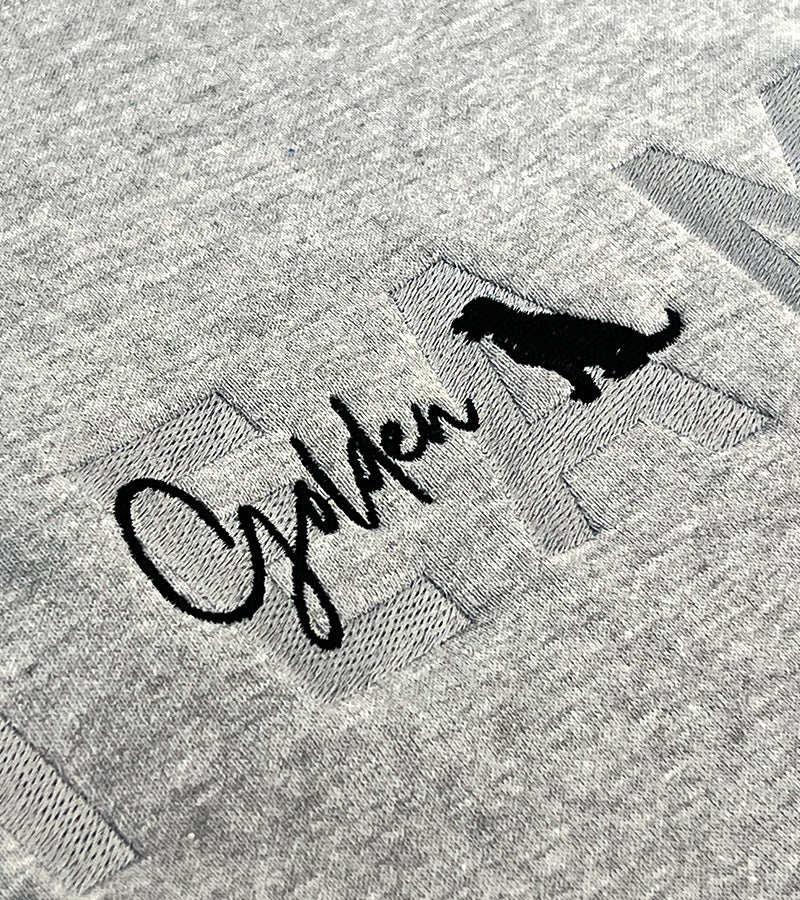 Gray fabric with 'Golden' embroidery and a black dog silhouette.