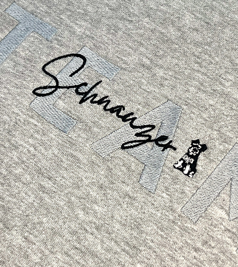 Embroidered text 'Schnauzer' on a grey fabric with dog icon