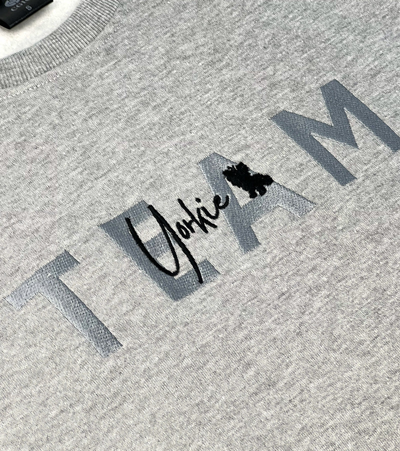 Gray sweater with 'Yorkie' logo and text on a textured fabric background