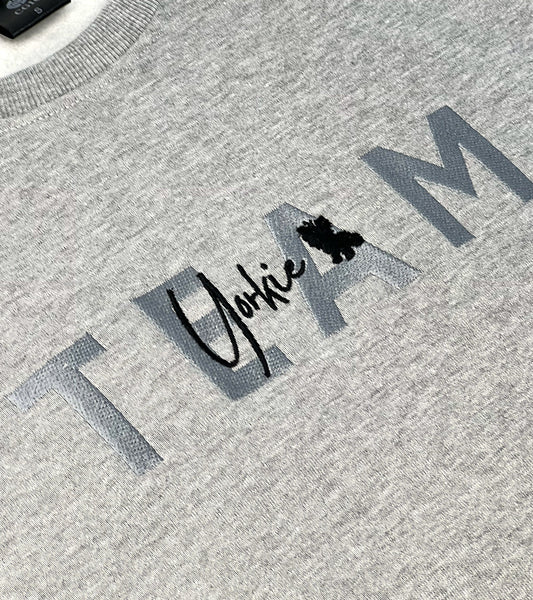 Gray sweater with 'Yorkie' logo and text on a textured fabric background