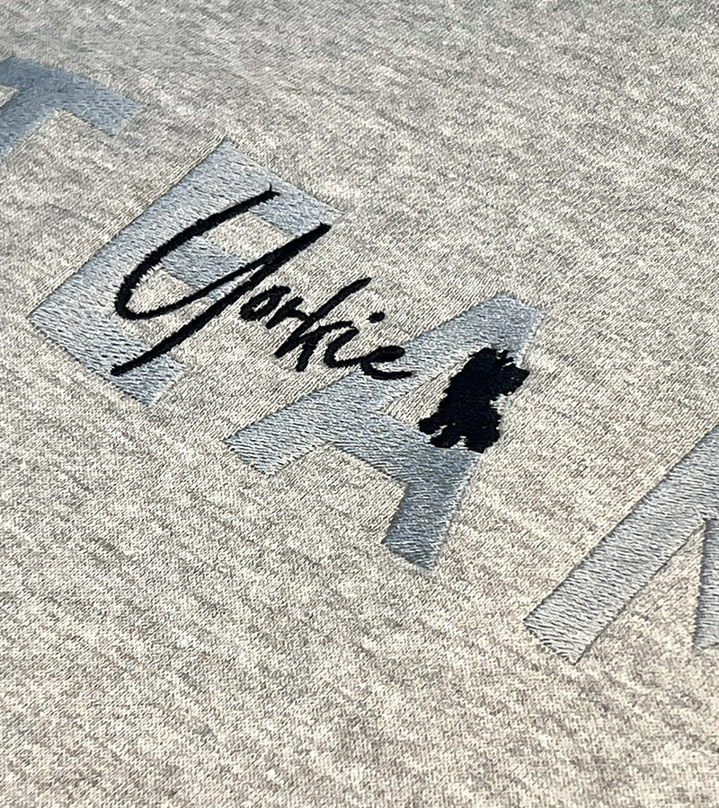 Embroidered 'Yorkie' with a small dog icon on a textured fabric background