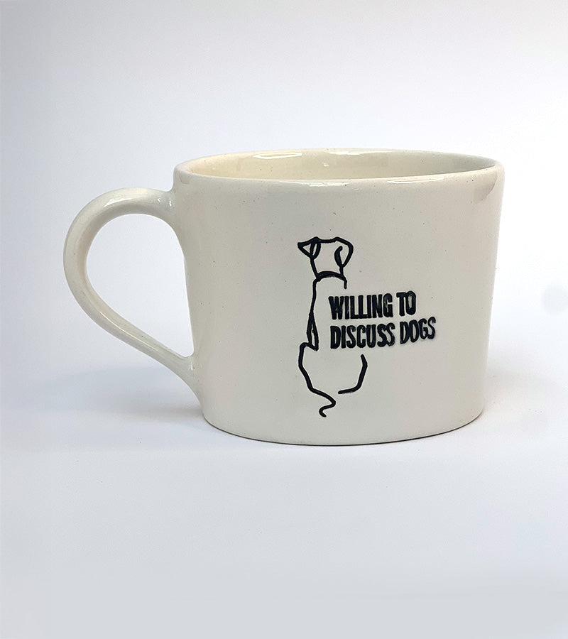 White mug with black 'Willing to discuss dogs' text and dog illustration on a white background