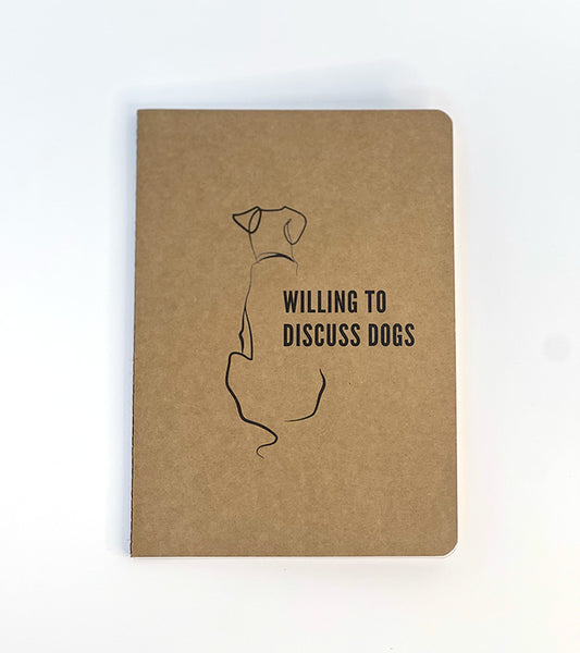 Paper notebook with a dog illustration and 'Willing to Discuss Dogs' text on a white background