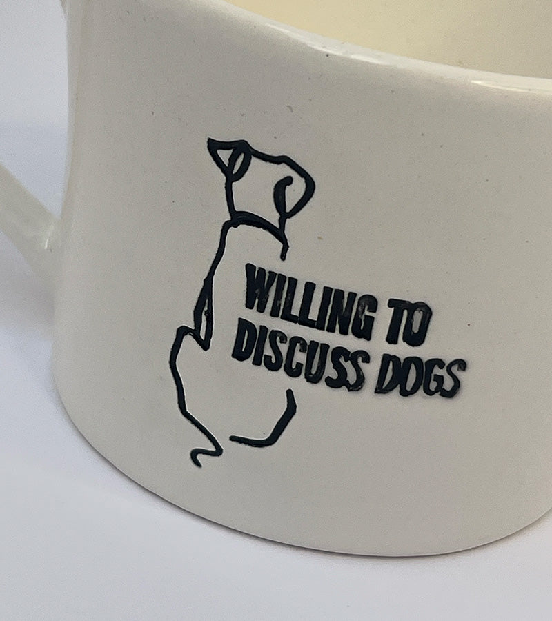 White mug with a black dog illustration and text 'Willing to Discuss Dogs' on a white background