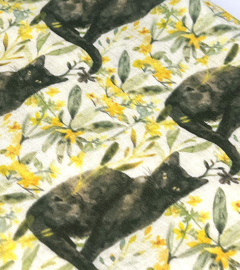 Fabric with black cat and floral pattern on a light background